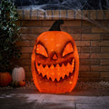 orange pumpkin light in garden with brick wall in background orange spooky lighting