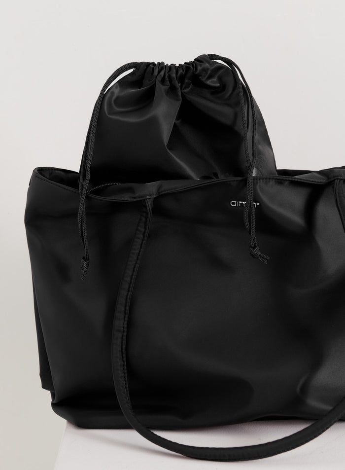 Musta sileäpintainen aim'n Nylon Tote Bag sisäisellä kiristysnauhapussilla.