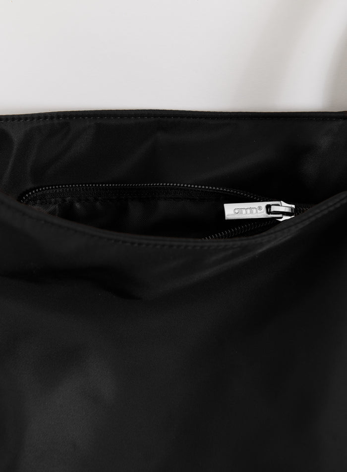 Lähikuva mustasta Nylon Weekend Bagista, jossa on hopeisella aim'n-logolla varustettu sisätaskun vetoketju.