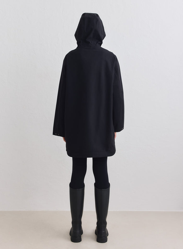 Musta, pitkä ja minimalistinen aim'n Waterproof Hood Jacket takaapäin huppu ylhäällä. [M-178cm]