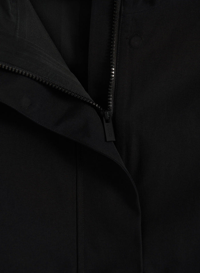Lähikuva mustan aim'n Waterproof Hood Jacket -takin vetoketjusta ja myrskylistasta
