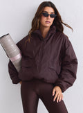 Suklaanruskea aim'n Cloud Jacket, ruskeat leggingsit ja rullattu joogamatto. [S-165cm]