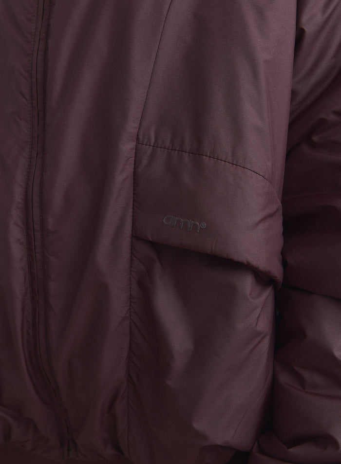Suklaanruskean Cloud Jacket -takin lähikuva sivutaskun aim'n-logolla. [S-165cm]