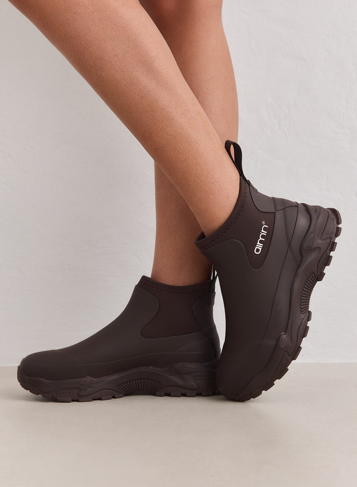 Vedenpitävät suklaanruskeat Fusion Rain Boot -kumisaappaat paksulla lenkkaripohjalla ja aim'n-logolla.