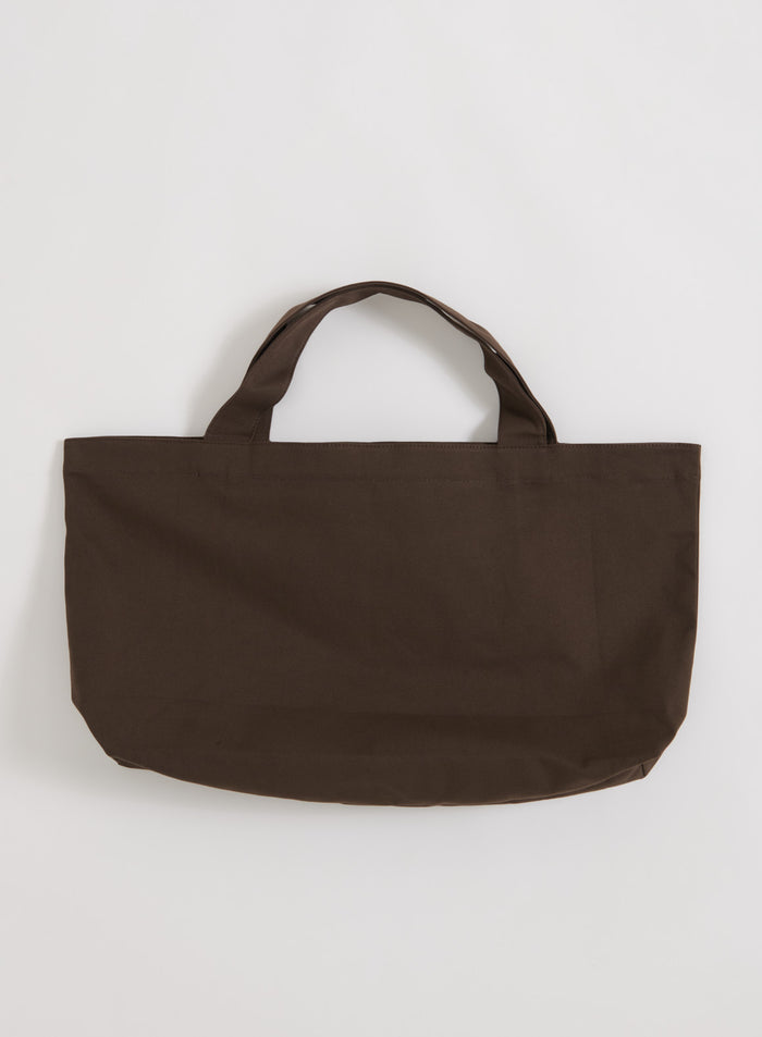 Suklaanruskea puuvillainen aim'n Varsity Tote Bag tasokuvassa.