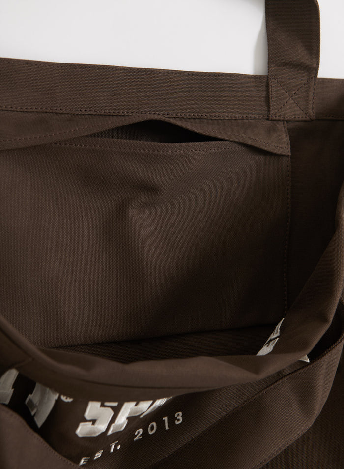 Suklaanruskean puuvillakankaisen aim'n Varsity Tote Bag -laukun sisätaskun yksityiskohta.