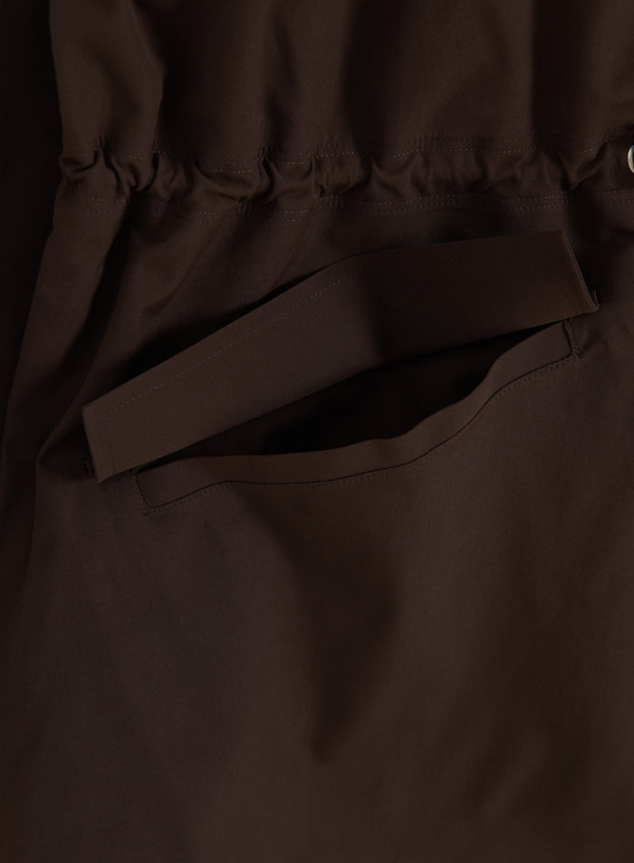 Suklaanruskean aim'n Waterproof Zip Jacket -takin yksityiskohta: läpällinen tasku ja säädettävä vyötärö.