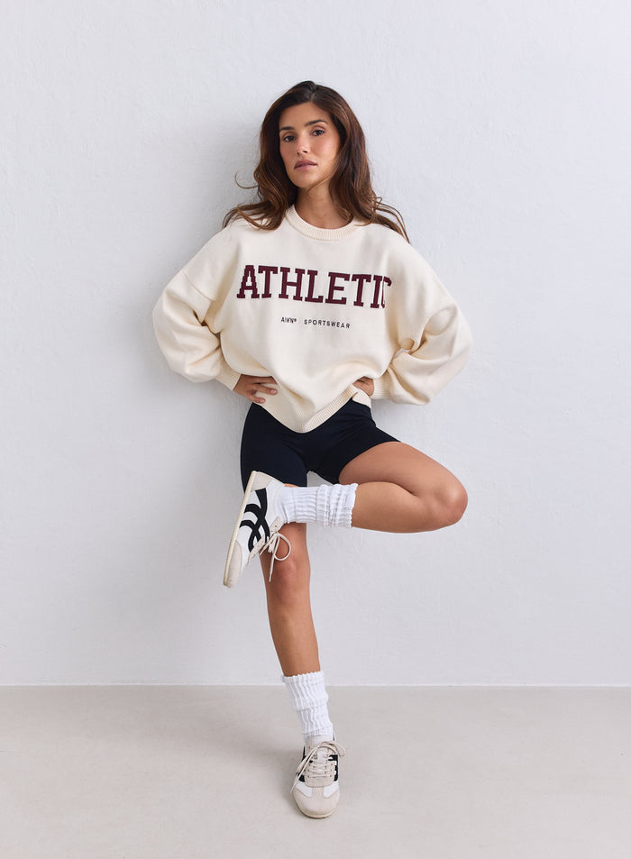 Kermanvaalea oversize-mallinen aim'n Athletic Knit Sweatshirt viininpunaisella tekstillä ja mustat shortsit. [S-165cm]