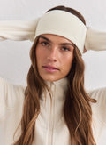 Nainen kermanvärisessä neulotussa aim'n Outdoor Logo Headband -pannassa ja yhteensopivassa fleecetakissa.
