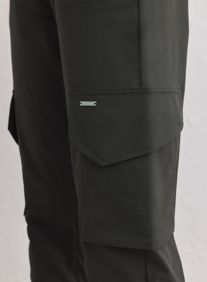 Dark Ivy Cargo Pants -housujen yksityiskohta, jossa on läpällinen sivutasku ja hopeinen aim'n-logolaatta. [xs-163cm]