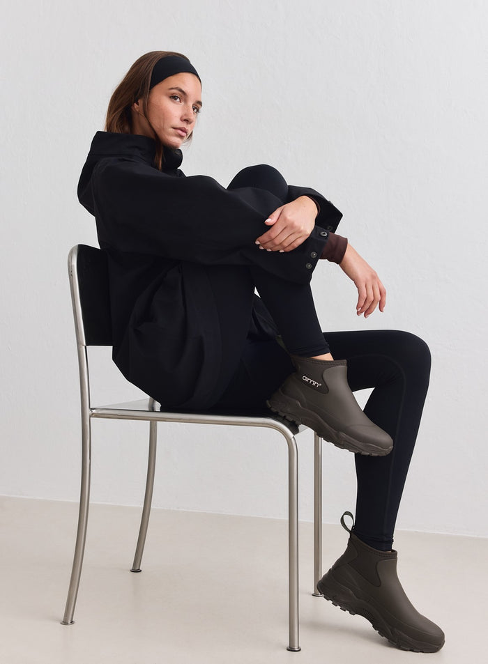 aim'n Dark Ivy Fusion Rain Boot -saappaat paksulla lenkkaripohjalla mallin yllä tuolilla istuessa.