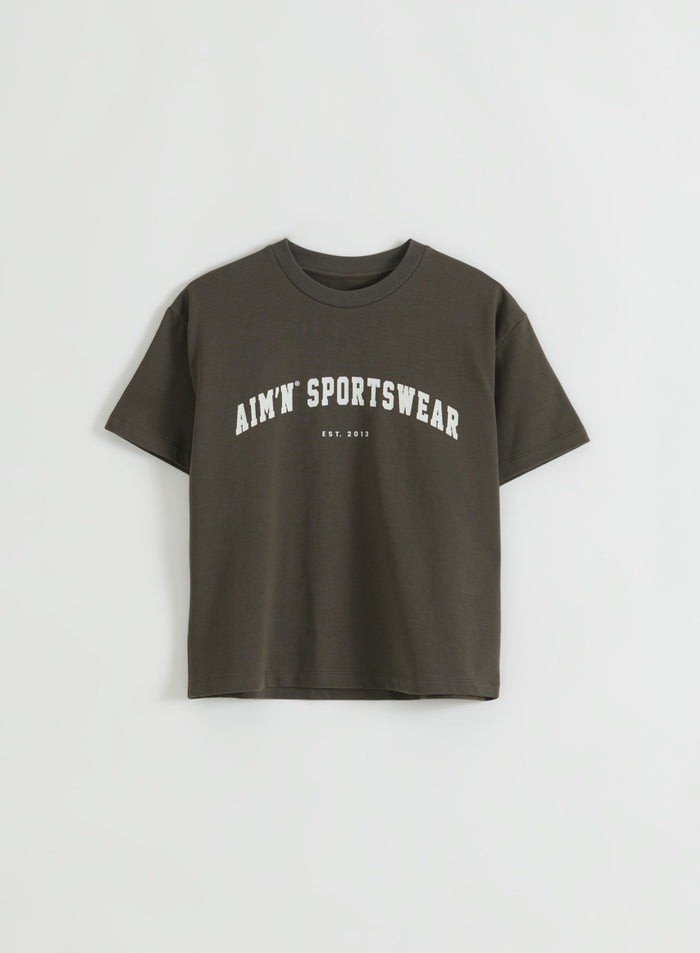 Dark Ivy -värinen laatikkomainen lyhythihainen T-paita, jossa on ribbineuloksinen pyöreä pääntie ja edessä urheiluaiheinen grafiikka