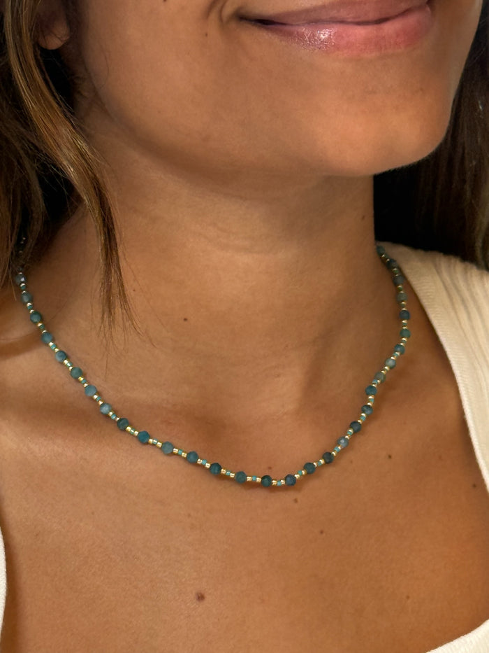 Model wearing The Faye Necklace in Teal, a teal apatite beaded necklace with stainless steel details.