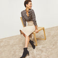 Front image of a woman standing wearing the Harlem skirt in latte | Lead