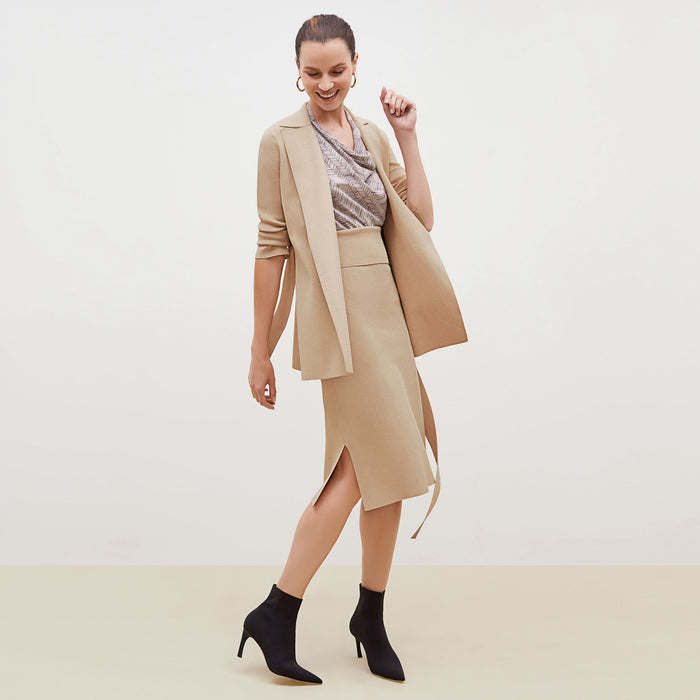 Side image of a woman standing wearing the Harlem skirt in latte