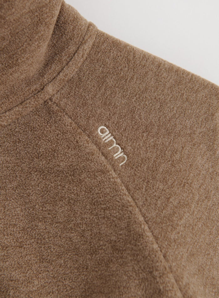 Lähikuva Hazelnut Fleece Zip Jacket -fleecetakista, jossa näkyy kirjailtu aim'n-logo olkapäässä