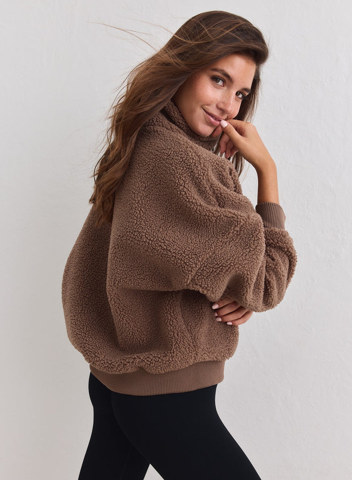 Pähkinänruskea Pile Half Zip -pusero pehmeällä sherpa-tekstuurilla mallin päällä. [xs-178cm]
