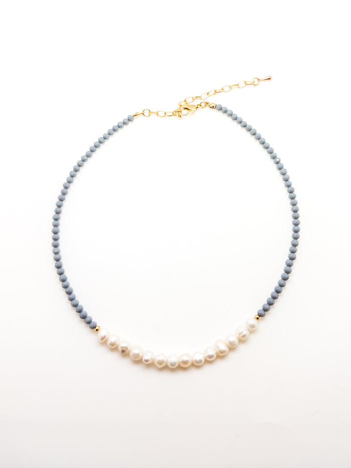 A dark blue beaded necklace with elegant white pearls, featuring an adjustable gold-colored chain.