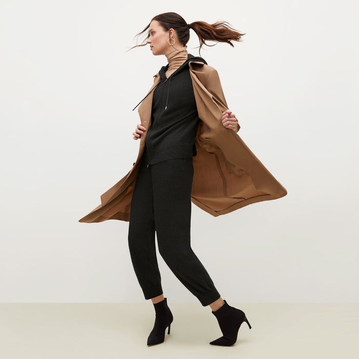 Side image of a woman standing wearing the Jensen trench in Saddle