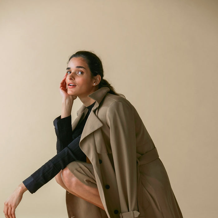 Side image of a woman standing wearing the Jensen trench in Saddle