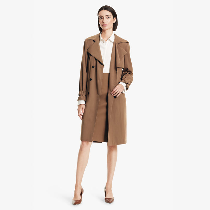 Front image of a woman standing wearing the Jensen trench in Saddle