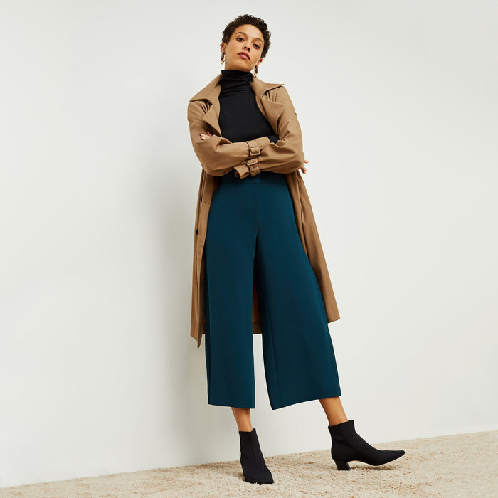 Front image of a woman standing wearing the Jensen trench in Saddle