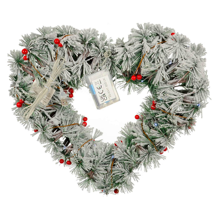 Back of a light up Christmas heart shaped wreath with red berries and battery compartment