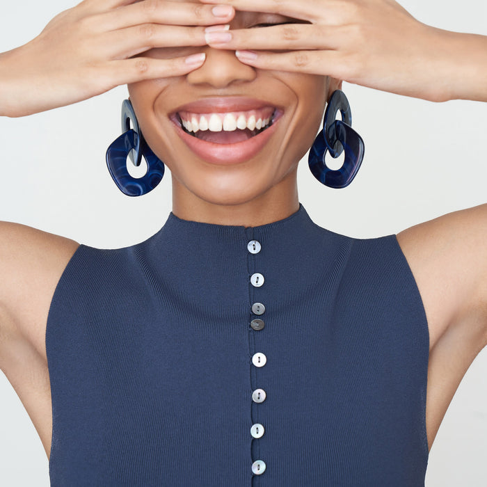 Detail image of a woman standing wearing the Malki Top in jardigan knit in Baltic Blue