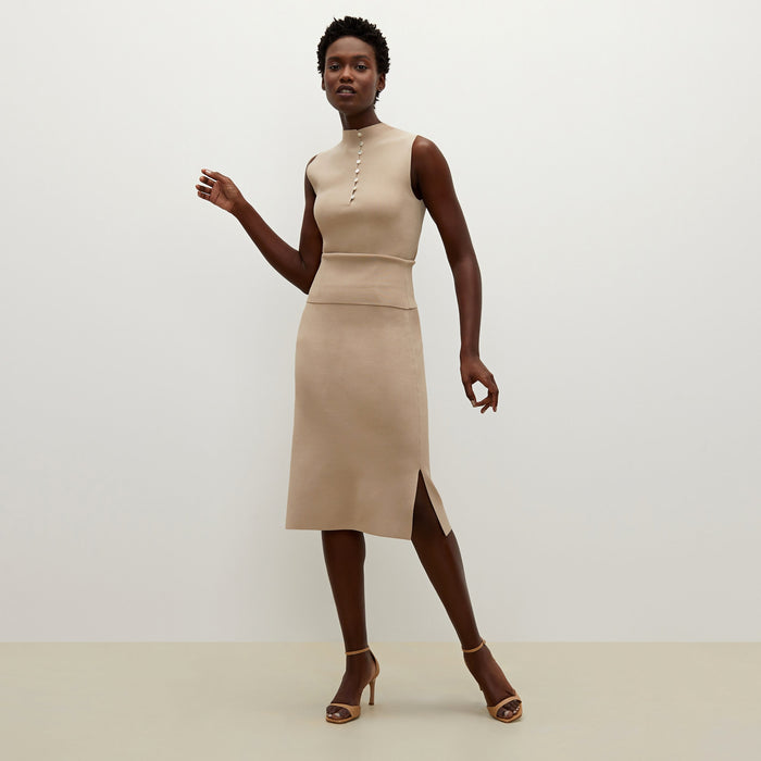 Side image of a woman standing wearing the Malki top in latte