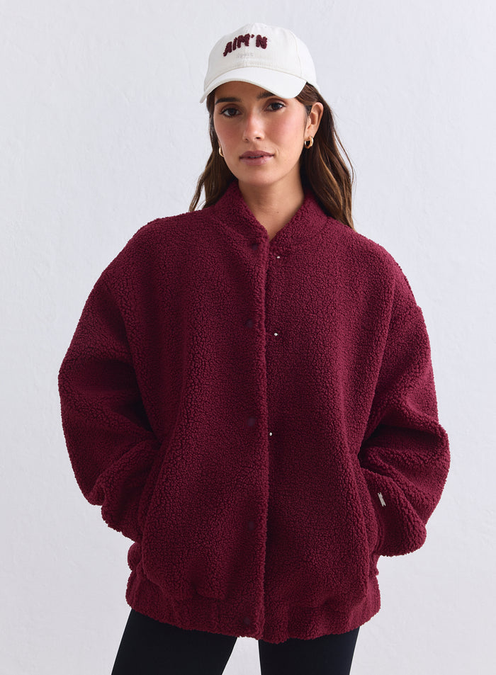 Rento merlot-punainen pile coach -takki pehmeää teddy-materiaalia ja kermanvaalea aim'n-lippis. [S-165cm]