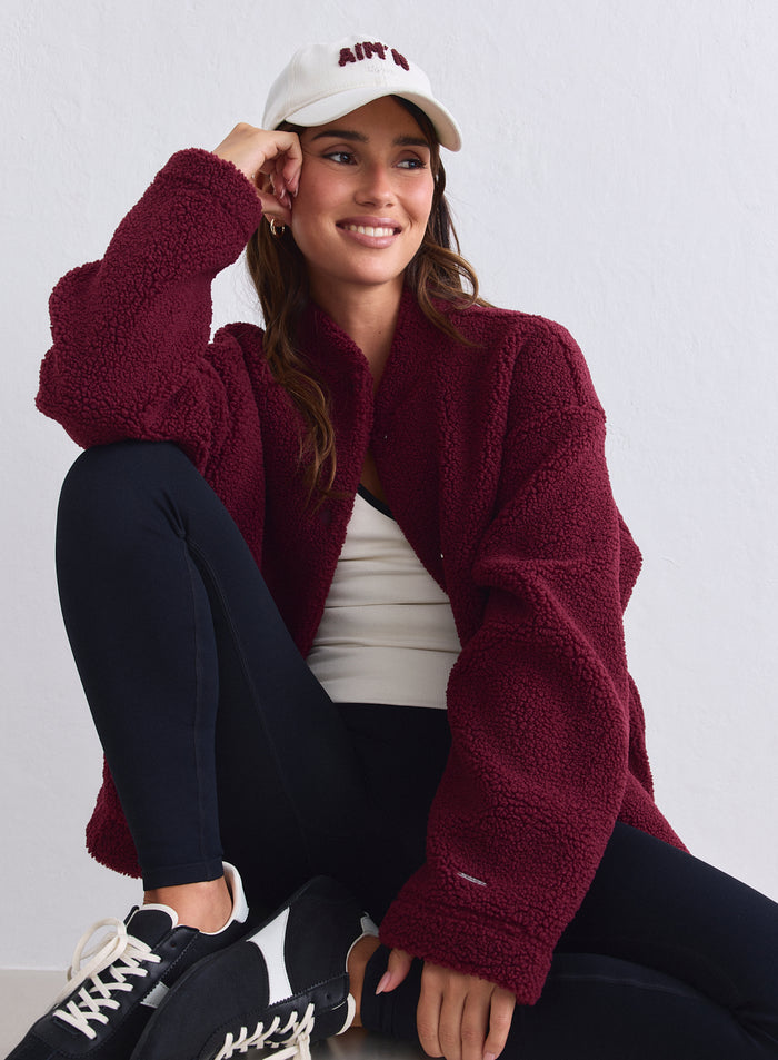 Rento merlot-värinen teddy-pile-takki yhdistettynä mustiin legginseihin ja aim'n-lippikseen [S-165cm]
