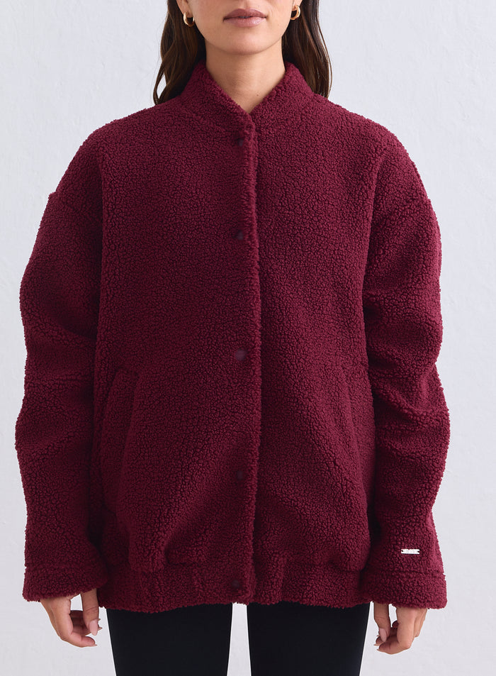 Pehmeä merlot-punainen aim'n pile coach jacket rennolla istuvuudella ja painonappikiinnityksellä. [S-165cm]