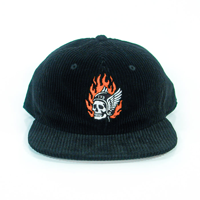 A black corduroy baseball cap from The Front Bottoms, featuring a flaming skull in a winged helmet and "1776" embroidered on the front, shown head-on against a white background. Ideal for fans of bold embroidered hats.