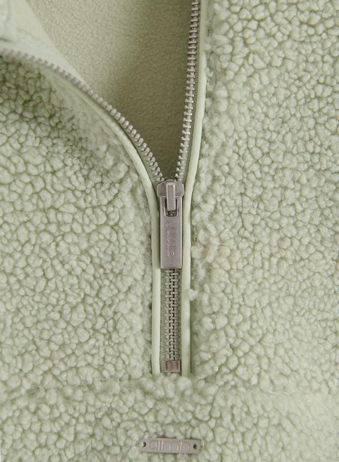 Lähikuva Pistachio Pile Half Zip -takin vetoketjusta ja pehmeästä nukkaisesta fleecemateriaalista