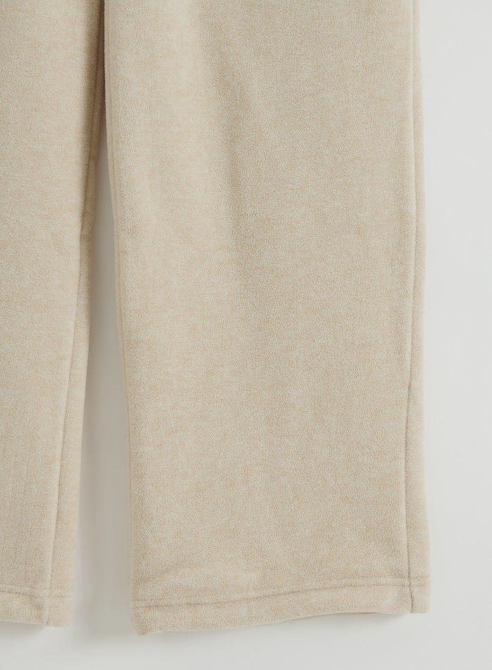 Lähikuva Sand Fleece Pants -housuista lattialla levitettynä