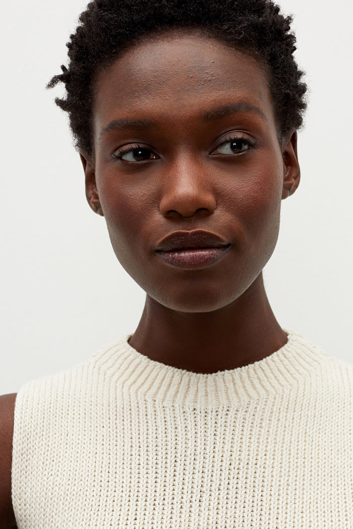 Detail image of a woman standing wearing the Spardel top in ivory | Grid Hover | Exclude