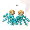 Turquoise beaded earrings with a golden shell accent, designed as a coastal-inspired statement jewelry piece.