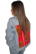 Blue washed denim trucker jacket with a bold tiger back patch print framed by pink and red vertical stripes.