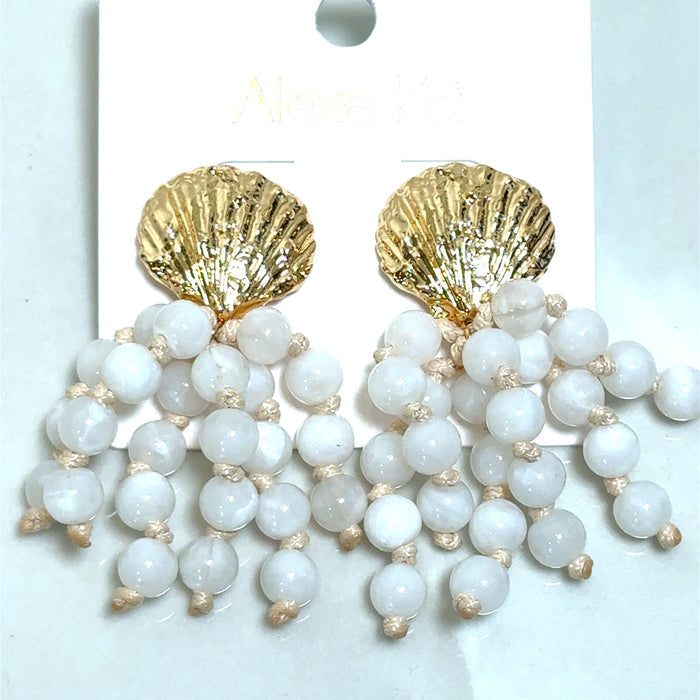 White beaded earrings featuring a golden shell-shaped detail for a coastal-inspired boutique jewelry look.